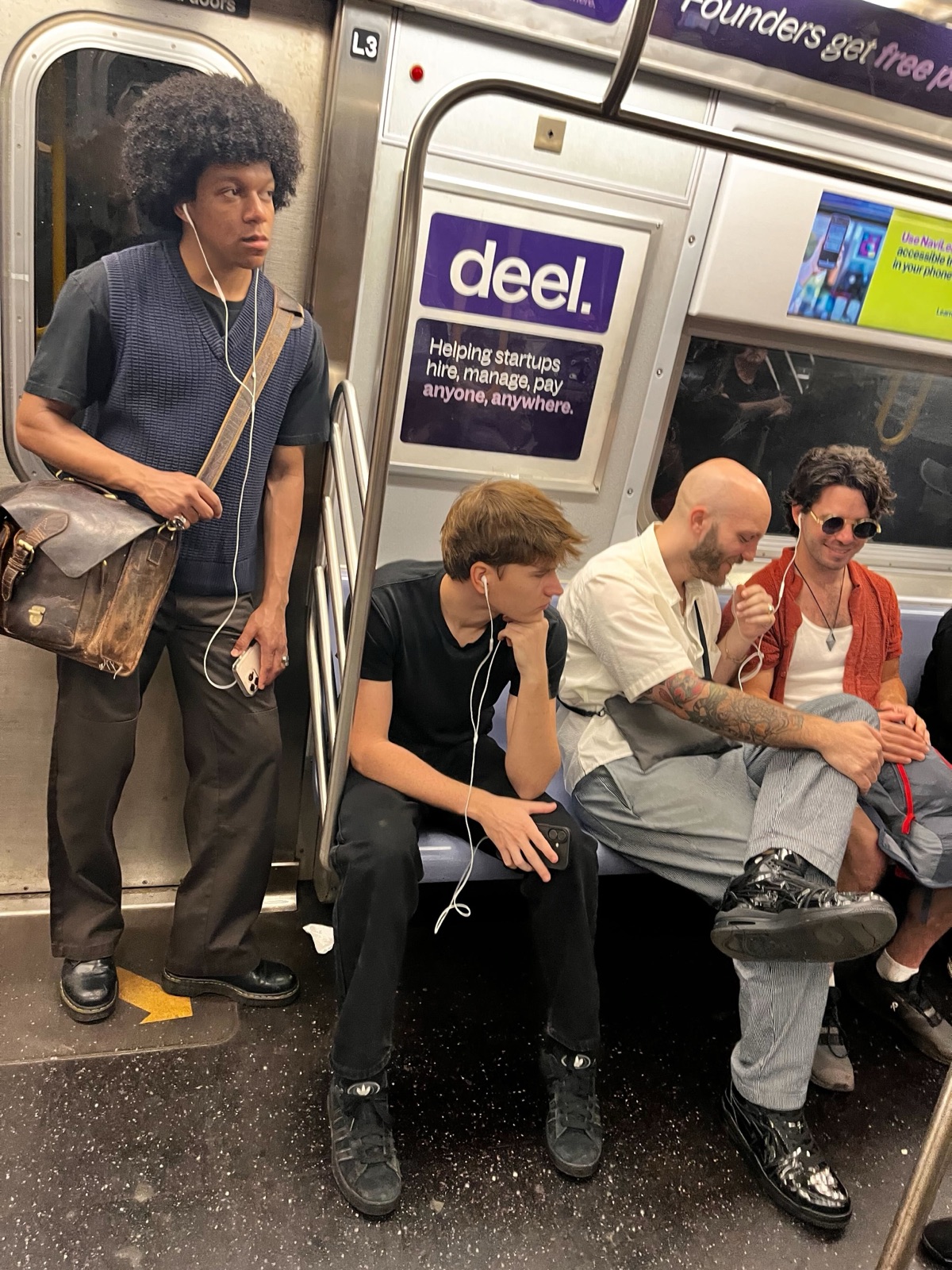 Subway riders on the D train wearing wired headphones — friction in the wild, June 2026