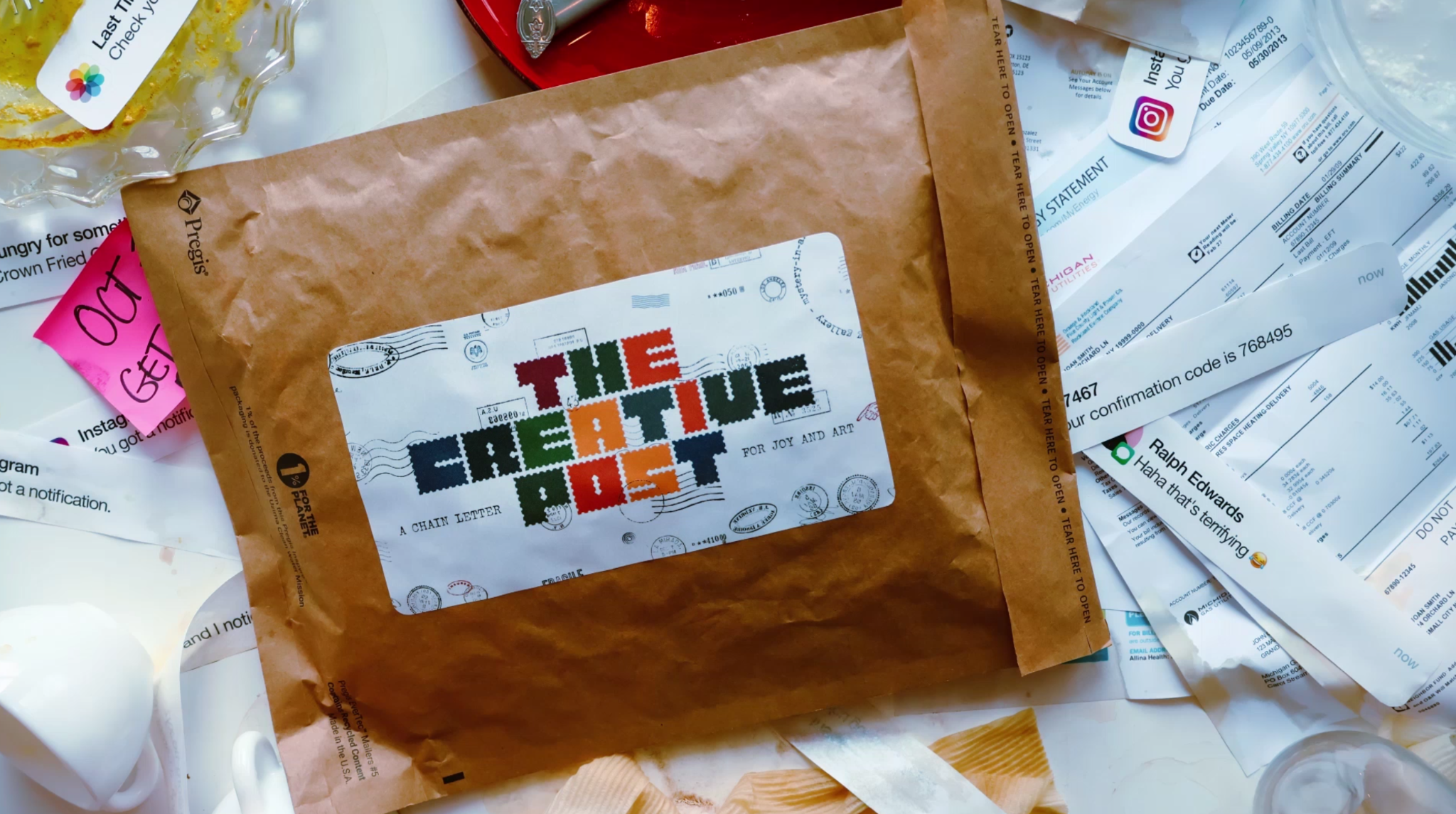 The Creative Post — a kraft-paper mailer amid a pile of envelopes and postcards