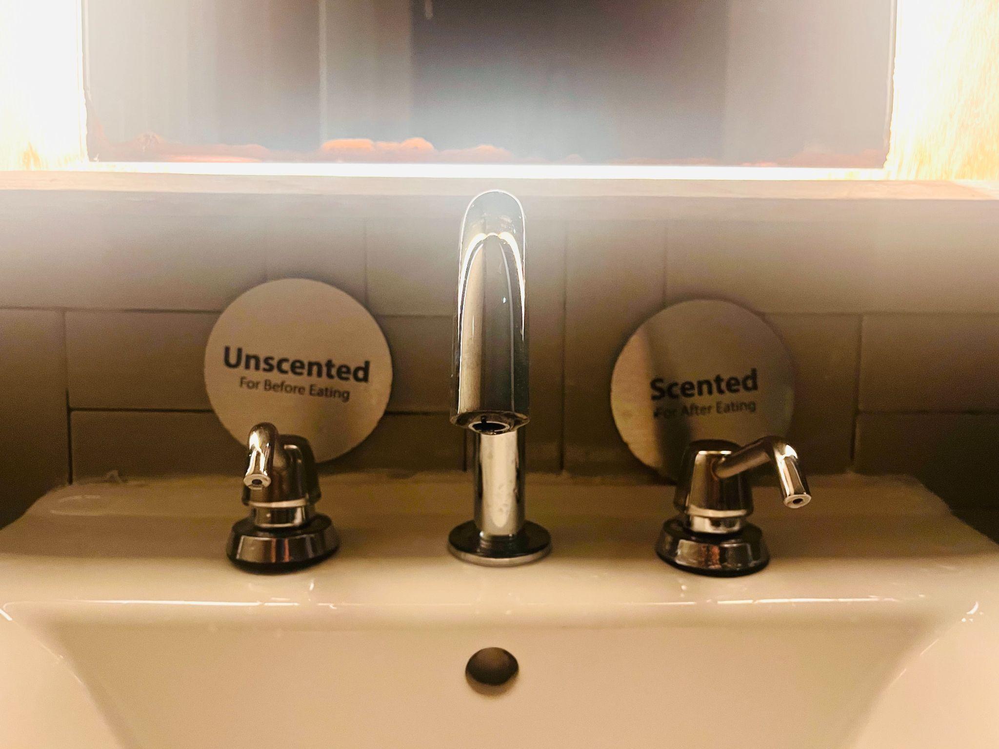 Scented and unscented hand soap options in a restaurant bathroom